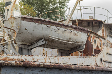 Fototapeta na wymiar Rusty weathered old white fishing boat in the harbor on the Dnieper River, Ukraine