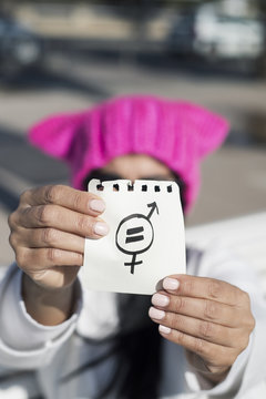woman with pussyhat and symbol for gender equality.