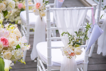 Chair decorated with flowers in Wedding ceremony.