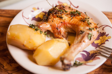 Chicken leg fried with spices on a plate with potatoes