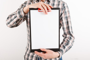 Business man in suit holding a blank clipboard