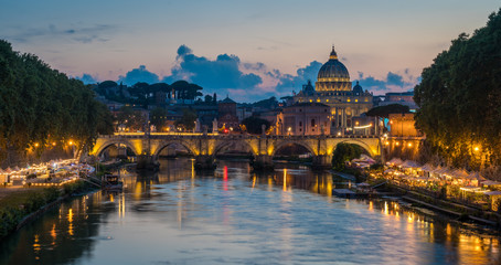 Fototapeta premium Panoramę Rzymu w letni wieczór, widzianą z mostu Umberto I, z Bazyliką Świętego Piotra w tle.