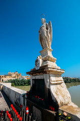Virgin Mary statue on famous Roman bridge of Cordoba across Guadalquivir River. Present structure of bridge dates from Moorish reconstruction in VIII centur