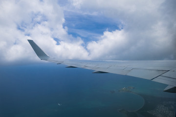 Naklejka premium Wing of airplane in the air with cloud