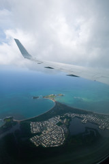 Wing of airplane in the air flying over city