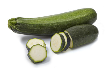 Whole and sliced zucchini isolated on white background.