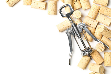 Heap of unused, new, brown natural wine corks with corkscrew on white, flat lay top view
