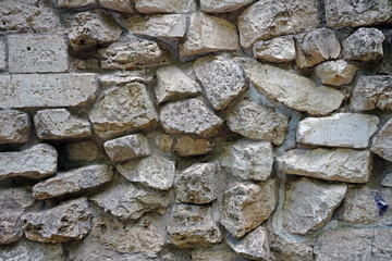 The wall of natural stones of different sizes.