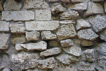The wall of natural stones of different sizes.