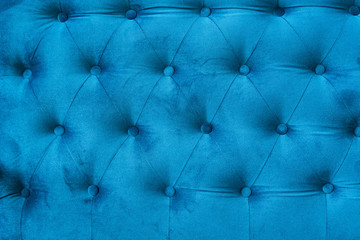 Velour surface of sofa close-up. Coach-type velours screed tightened with buttons. Blue...