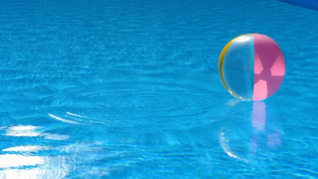 Beach ball floating in pool
