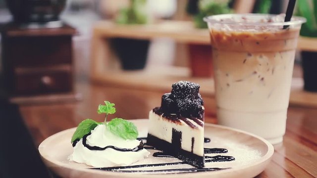 A cup of cappuccino coffee with a pice of chocolate cheesecake and mint leaf moving, Cinemagraph