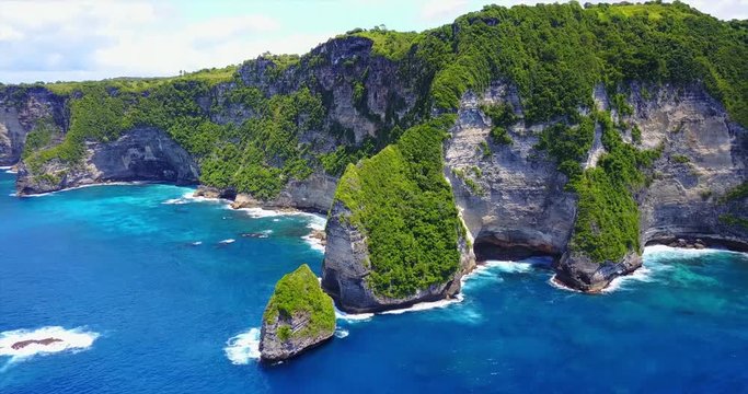 Reverse Aerial View Of Sharp Rocky Coastal Cliffs Overlooking Blue Tropical Coastline - The Nusa Penida Banah Cliffs, Indonesia