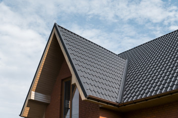 Modern roof covered with tile effect PVC coated brown metal roof sheets.