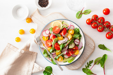 healthy colorful vegan tomato salad with cucumber, radish, onion