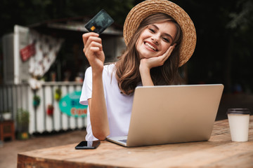 Happy young girl showing plastic credit card