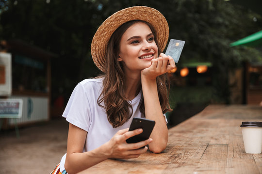 Happy young girl holding plastic credit card