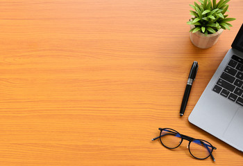 Working with Laptop computer Hot coffee and cactus copy space on wood table background.Top view Flat lay style Minmal workspace