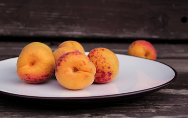 Ripe organic apricots on the wooden background. Space for text. Blurred background.