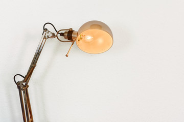 Table lamp powered on with white wall as a background
