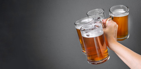 Oktoberfest concept - hand holding glasses with beer