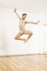 Young beautiful male  ballett dancer jumping in studio