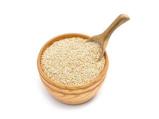 Round wooden bowl filled with healthy quinoa seeds and a spoon isolated on white background