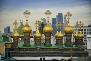 old domes of the temple against the background of a modern city