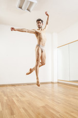 Young beautiful male  ballett dancer jumping in studio