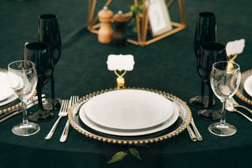 White porcelain plate stands on table covered with dark green cloth