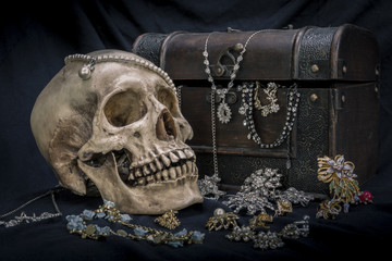 Still life with a human skull with old treasure chest and gold, diamond