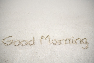 The text Hello morning written on the sand beach by the sea, used in greeting