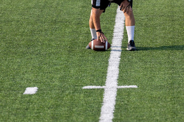 Referee setting football on field 