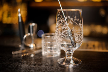 Empty cocktail glass with a spoon in it on the bar counter