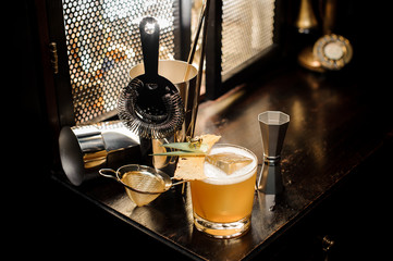 Top view of tasty and sour yellow decorated alcoholic summer cocktail and utensils arranged on the...