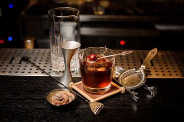 Cocktail glass filled with strong and sweet summer cocktail decorated with cherry