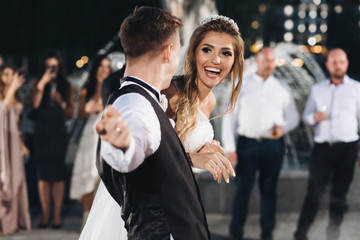 Bride and groom dance with their friends in the hall