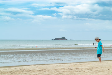 Asian boy walking on the beach by the sea