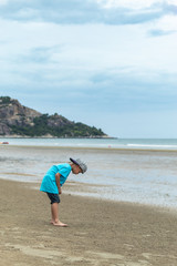 Fototapeta na wymiar Asian boy walking on the beach by the sea