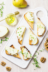 Pear and brie, honey crostini toasts on marble background. Top view, space for text.