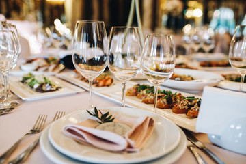 Sparkling crystal glasses stand on rich served dinner table