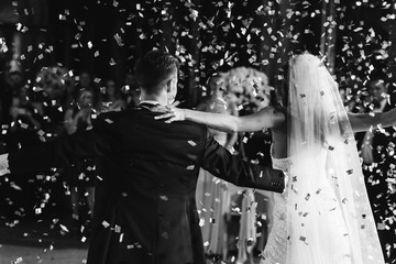 Confettie falls over bride and groom while they dance