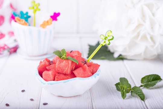 Ceramic bowl with watermelon cubes on a white background