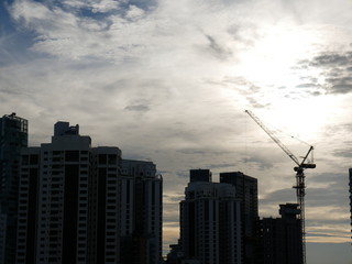 Fototapeta na wymiar Sunset behind buildings with beautiful cloudy sky