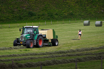 Traktor auf dem Feld bei der Heuernte  