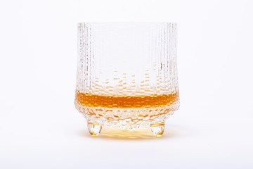 Glass of whiskey in a design glass isolated on white background