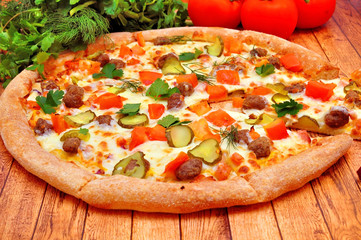 Pizza with meat, cucumbers, tomatoes and greens