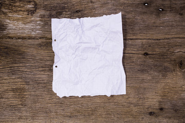 White paper has a square slot with wrinkles. Put on old wooden boards with beautiful woods.