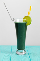Natural vegetable cocktail with kiwi and other greens. A cocktail is decorated with kiwi with a yellow straw. A fresh drink for people who watch their health.