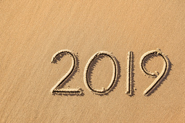 new year 2019 written in sand